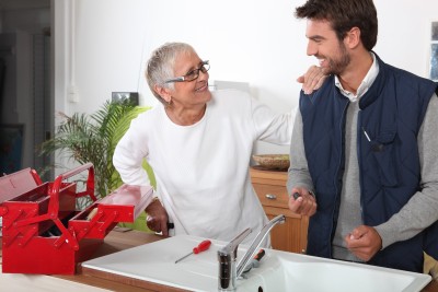 Campbell plumber installs a kitchen faucet while consulting customer